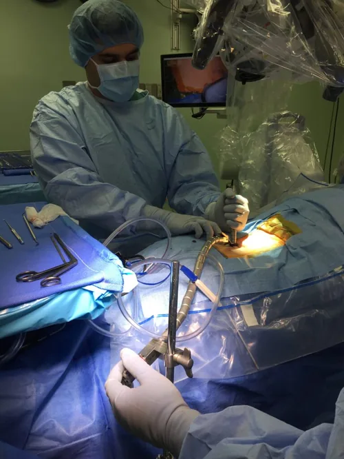 Dr. Shakir performs minimally invasive, motion-preserving operation with the microscope — alleviating pain while maintaining flexibility and allowing patients to resume normal lifestyles